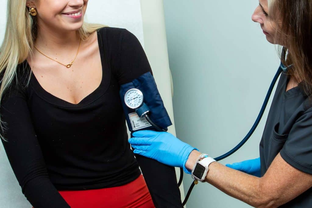 Woman getting blood pressure checked for routine check up at doctors office in orlando