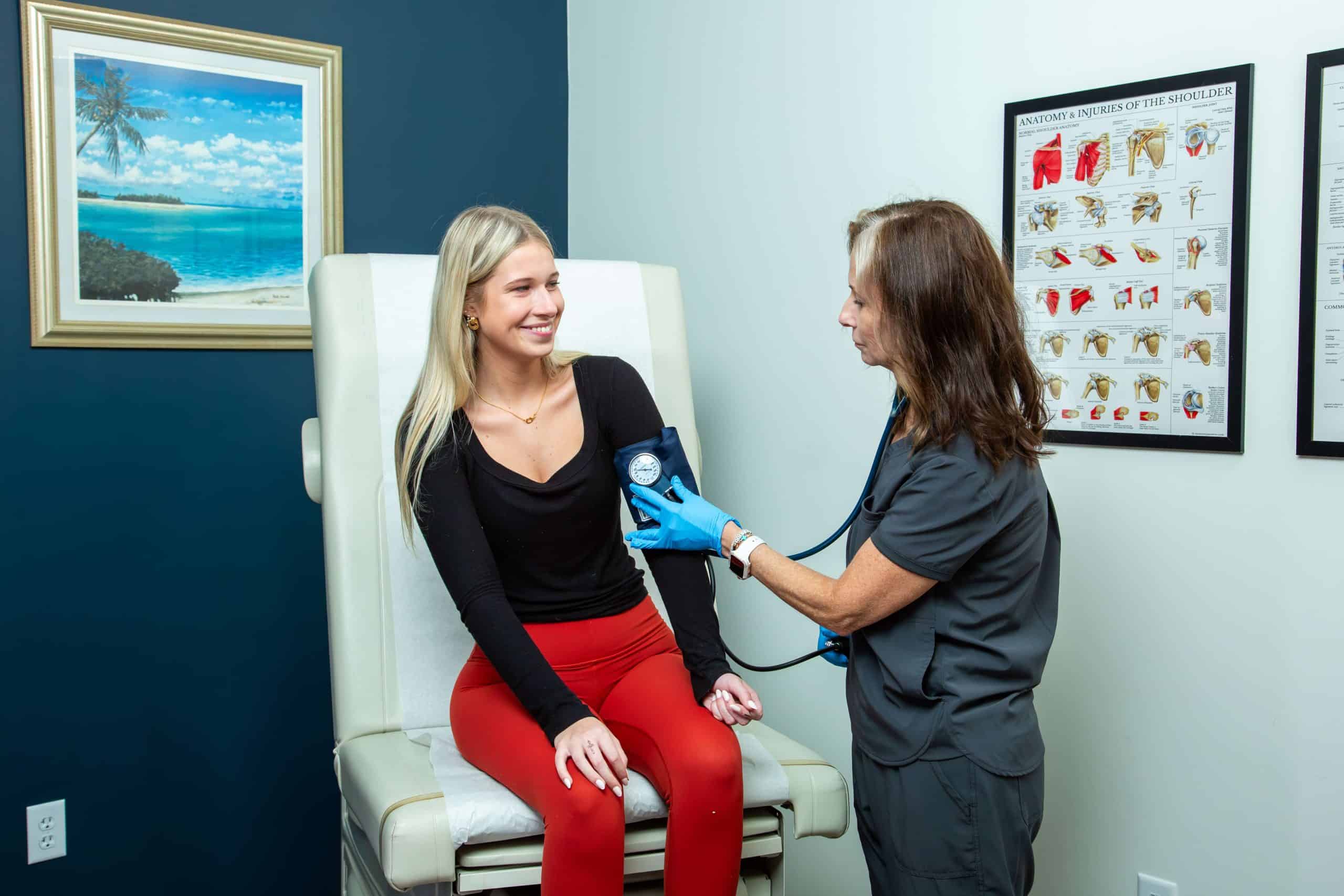 Doctor taking blood pressure of patient in chiropractic orlando center