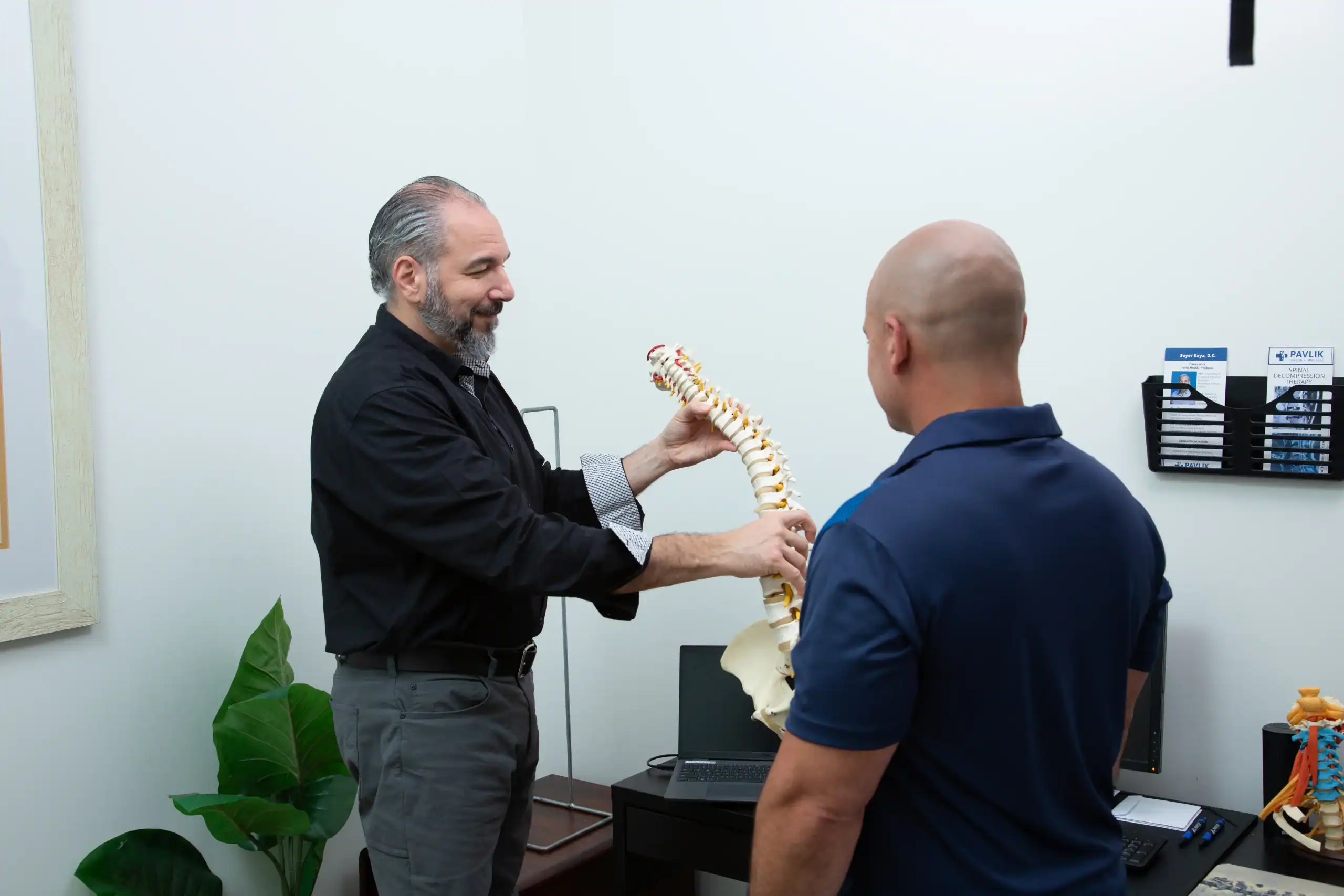 Doctor showing the spine to a person looking to get spinal decompression therapy in Orlando